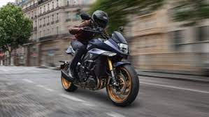 Suzuki Katana 2022: side view staged with rider and colourful background Suzuki Katana 2022: side view staged with rider and colourful background