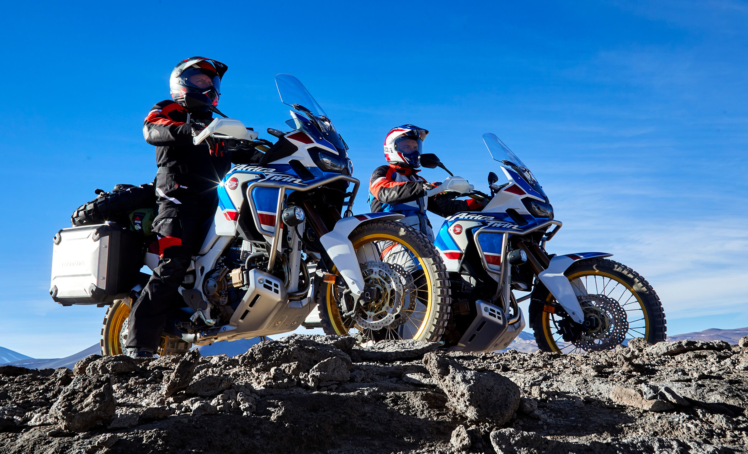 Two Honda Adventure-tourers on a crest overlooking a valley (assumedly)