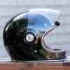 Side view of Bell Bullitt Helmet sitting on wooden surface with face shield raised
