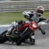 A view of a racer leaning into the twisties while giving a big thumbs up