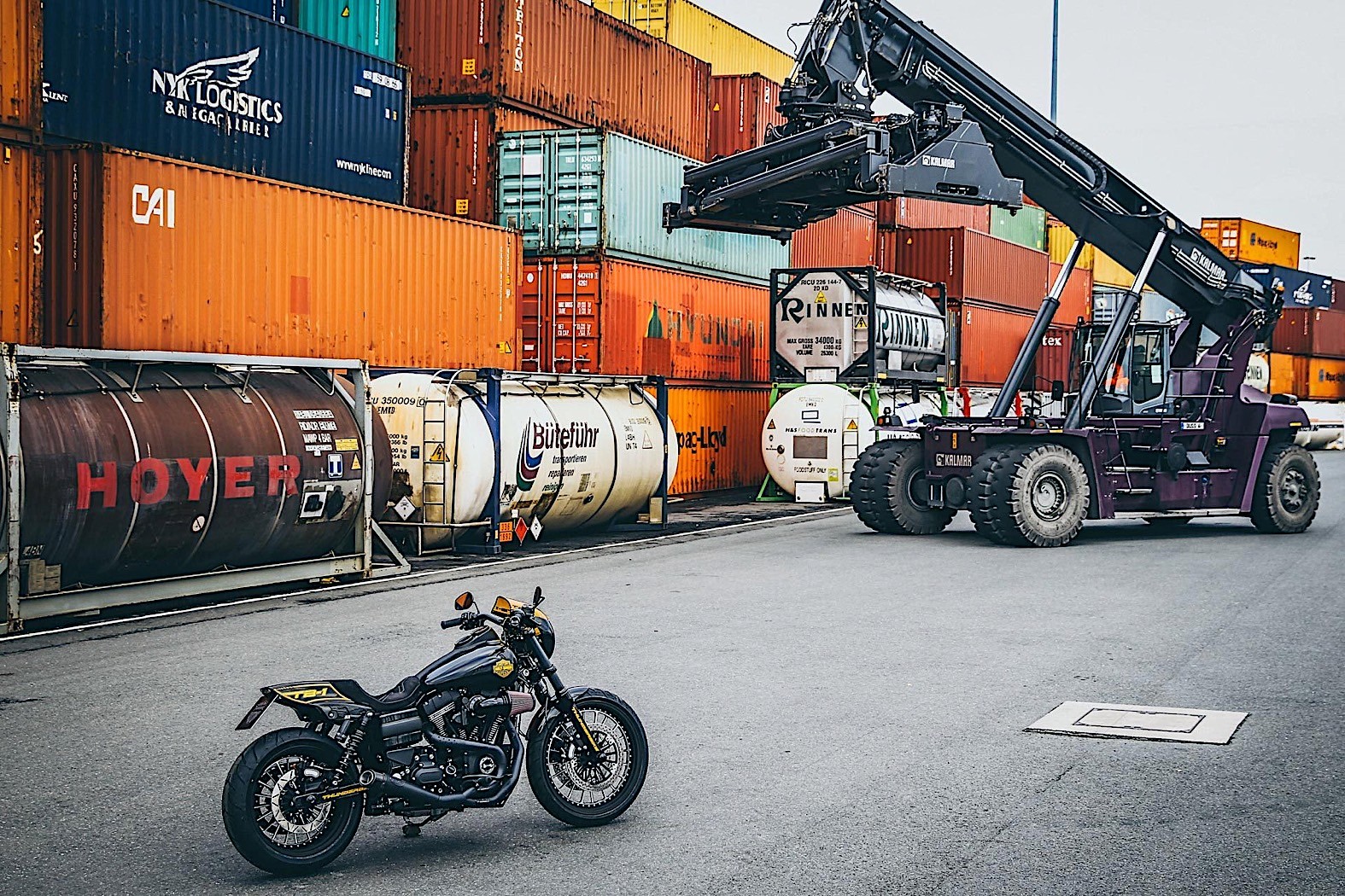 A Harley-Davidson TB 1 superbike in front of a series of shipping containers