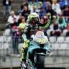 Valentino Rossi waving to fans while on his Yamaha supersport machine