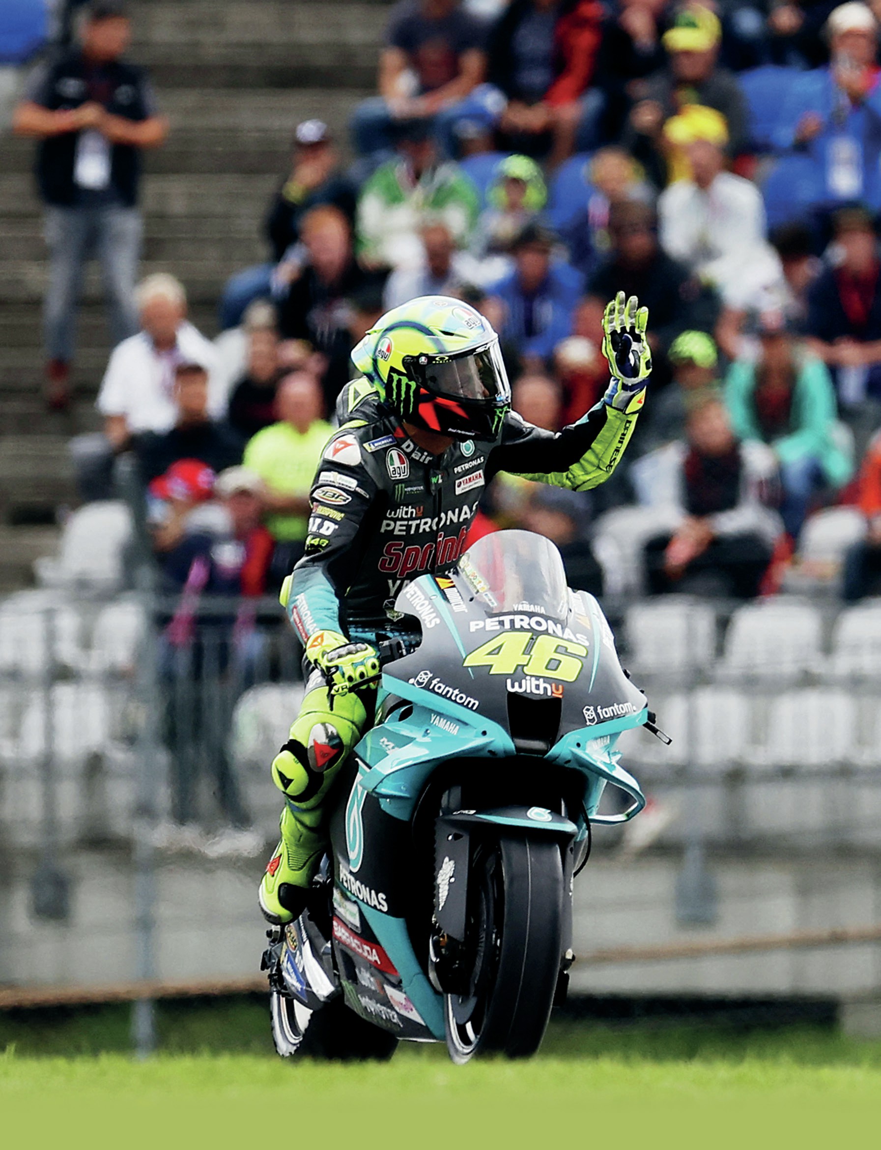 Valentino Rossi waving to fans while on his Yamaha supersport machine