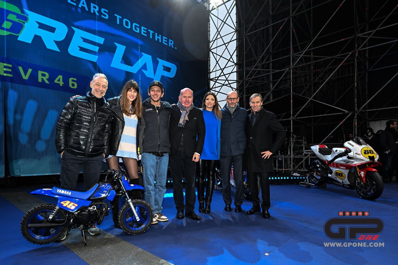 Valentino Rossi and select important members of the man's career and accomplishments, taking a picture on the stage of the "one More Lap' event at 2021 EICMA