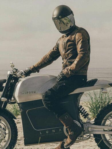 A Zero Motorcycle with a rider stride in front of a desert-like topography