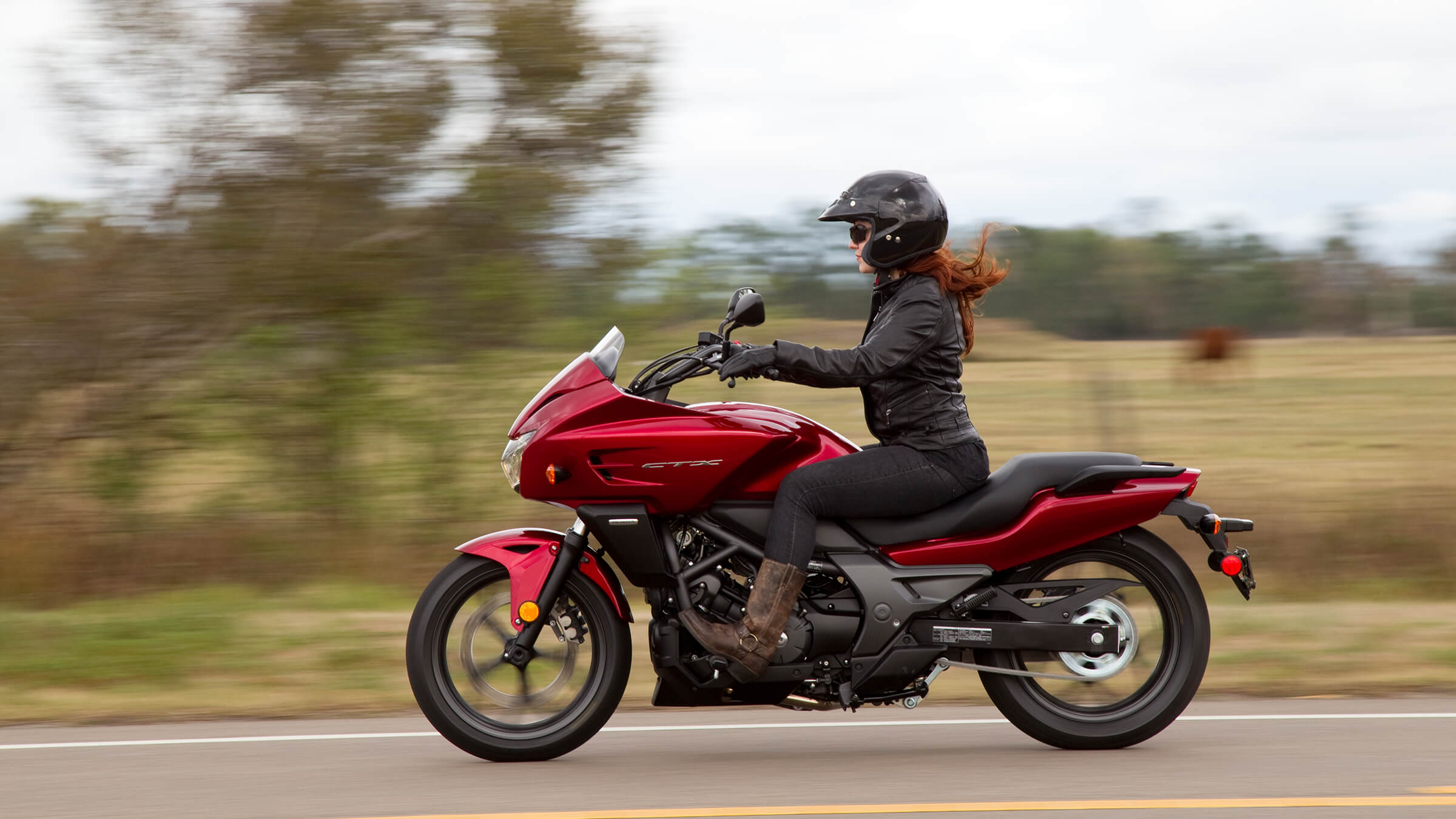 A view of a Honda motorcycle with a rider leaning into the twisties.