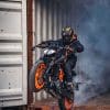 A motorcyclist rides out of a shipping container