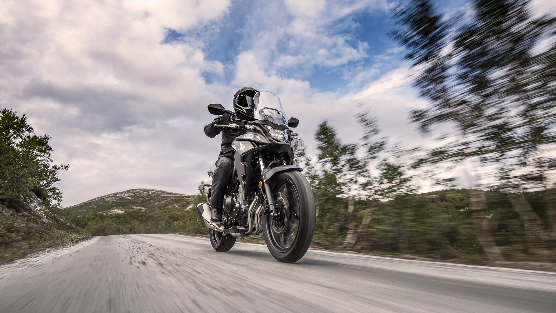 2021-Honda-CB500X with rider taking the bike through forest-like topography