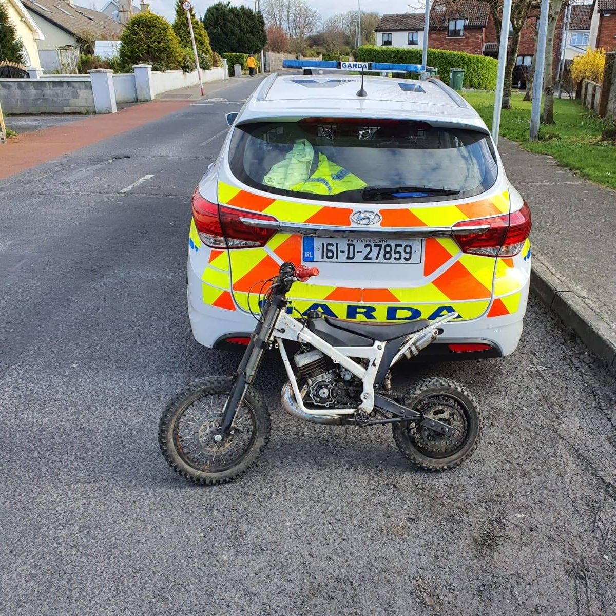 A view of a police car after having apprehended a scrambler from some Irish youth