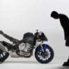 A view of a man bowing to a Yamaha motorcycle that's been stripped