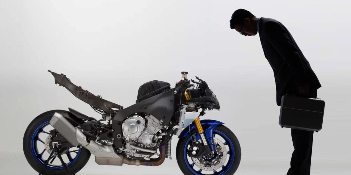A view of a man bowing to a Yamaha motorcycle that's been stripped