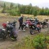 Group of adventure motorcycle riders parked off-road