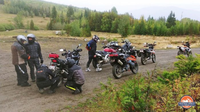 Group of adventure motorcycle riders parked off-road