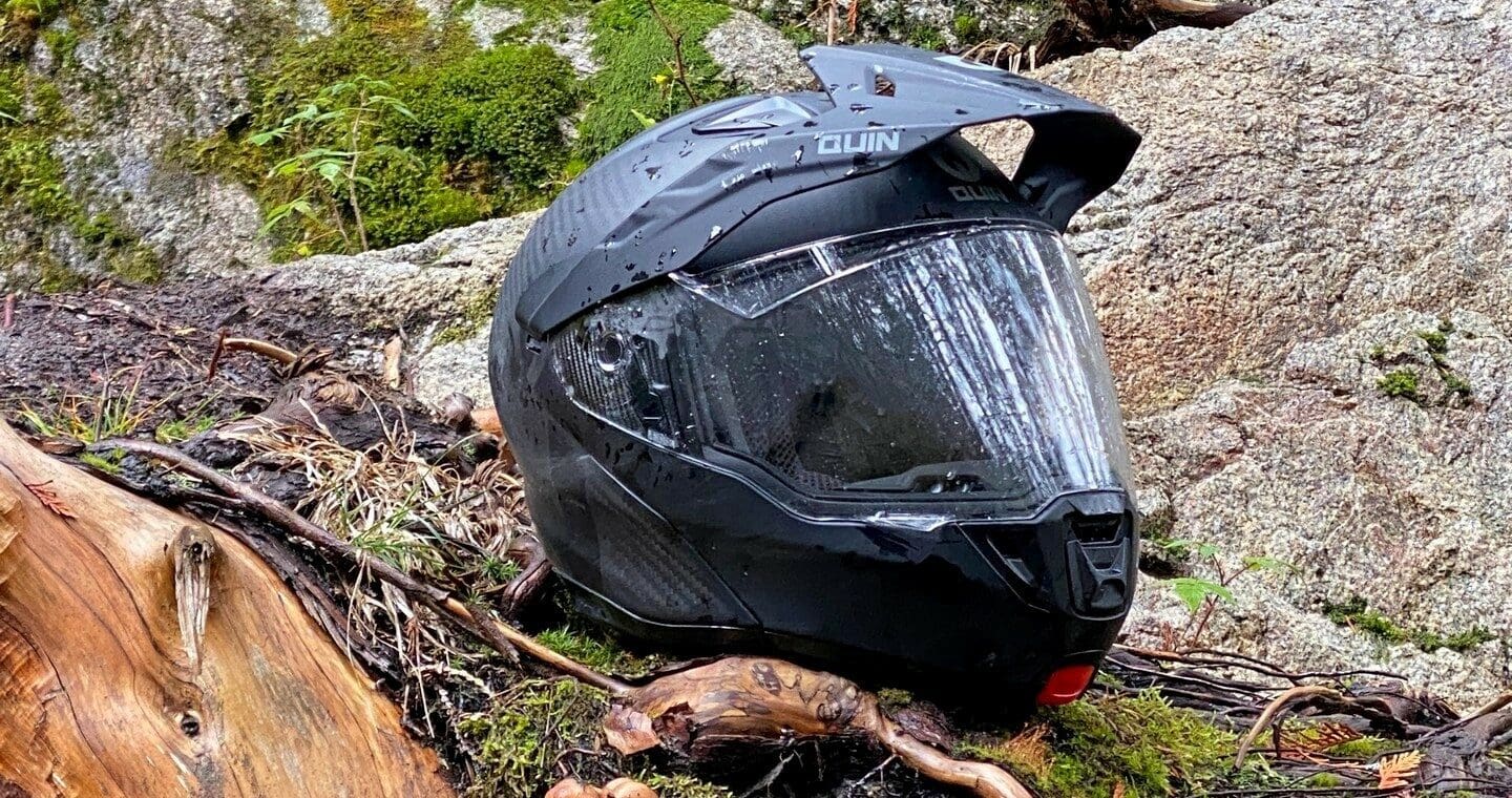 Quin Quest Smart Helmet sitting on mossy rock in forest