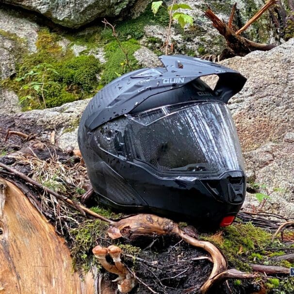 Quin Quest Smart Helmet sitting on mossy rock in forest