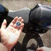 A view of an Apple AirTag next to a motorcycle