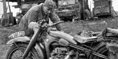 A german soldier tends to his BMW motorcycle during WWII