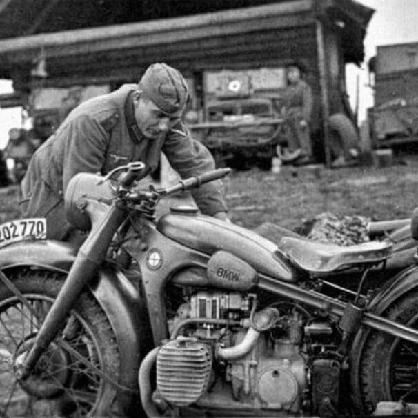 A german soldier tends to his BMW motorcycle during WWII