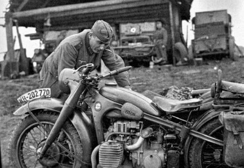 A german soldier tends to his BMW motorcycle during WWII