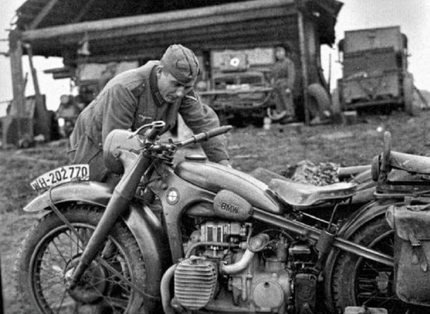 A german soldier tends to his BMW motorcycle during WWII