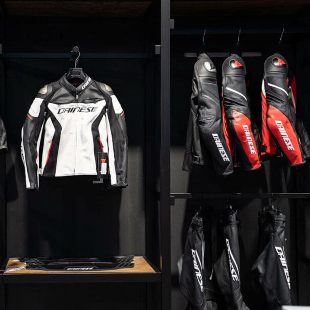 A view of several Dainese motorcycle suits on the rack at a store