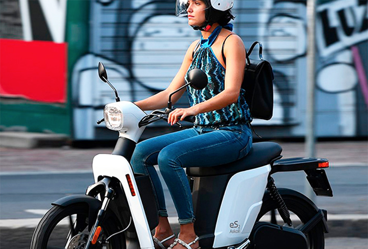A view fo a female riding a scooter