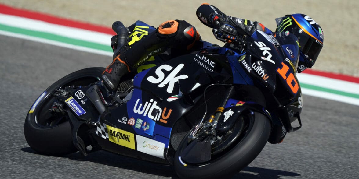 A side view of a racer in the MotoGP grid, racing his motorcycle