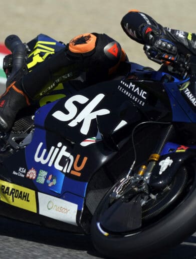 A side view of a racer in the MotoGP grid, racing his motorcycle