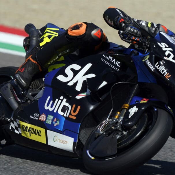 A side view of a racer in the MotoGP grid, racing his motorcycle