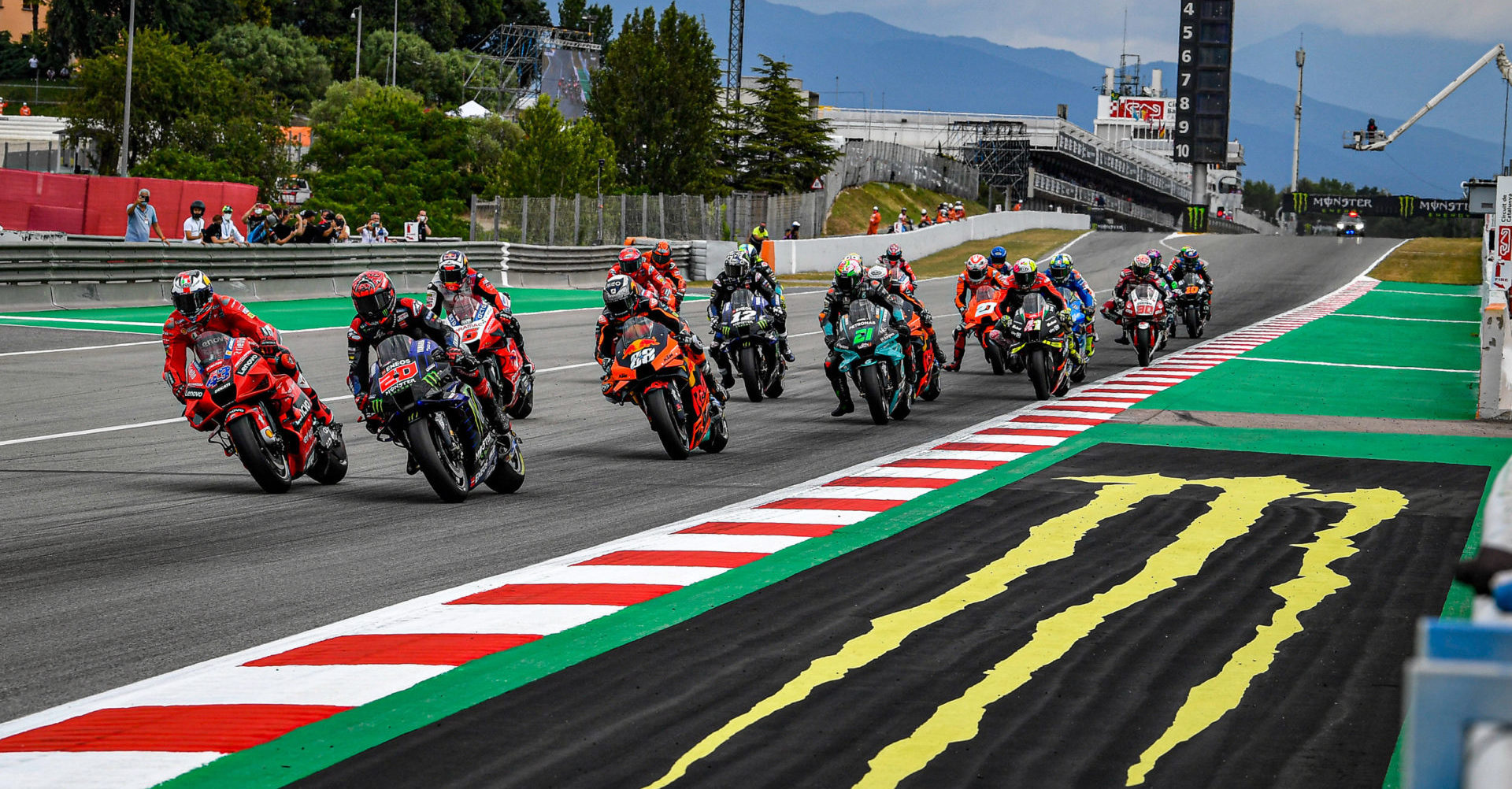 A side view of a racer in the MotoGP grid, racing his motorcycle