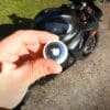 A view of an Apple AirTag next to a motorcycle