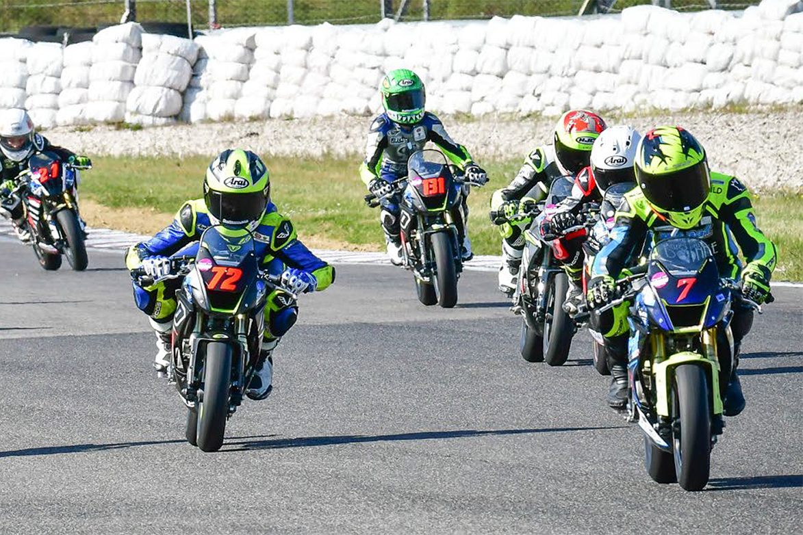 A view of MiniGP riders in the race to win the cup and continue forward in the pursuit toward MotoGP