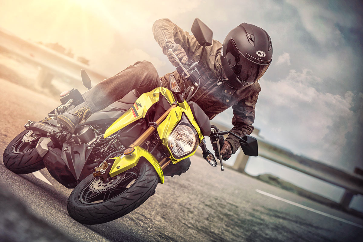 Rider cornering on yellow Kawasaki Z125 Pro