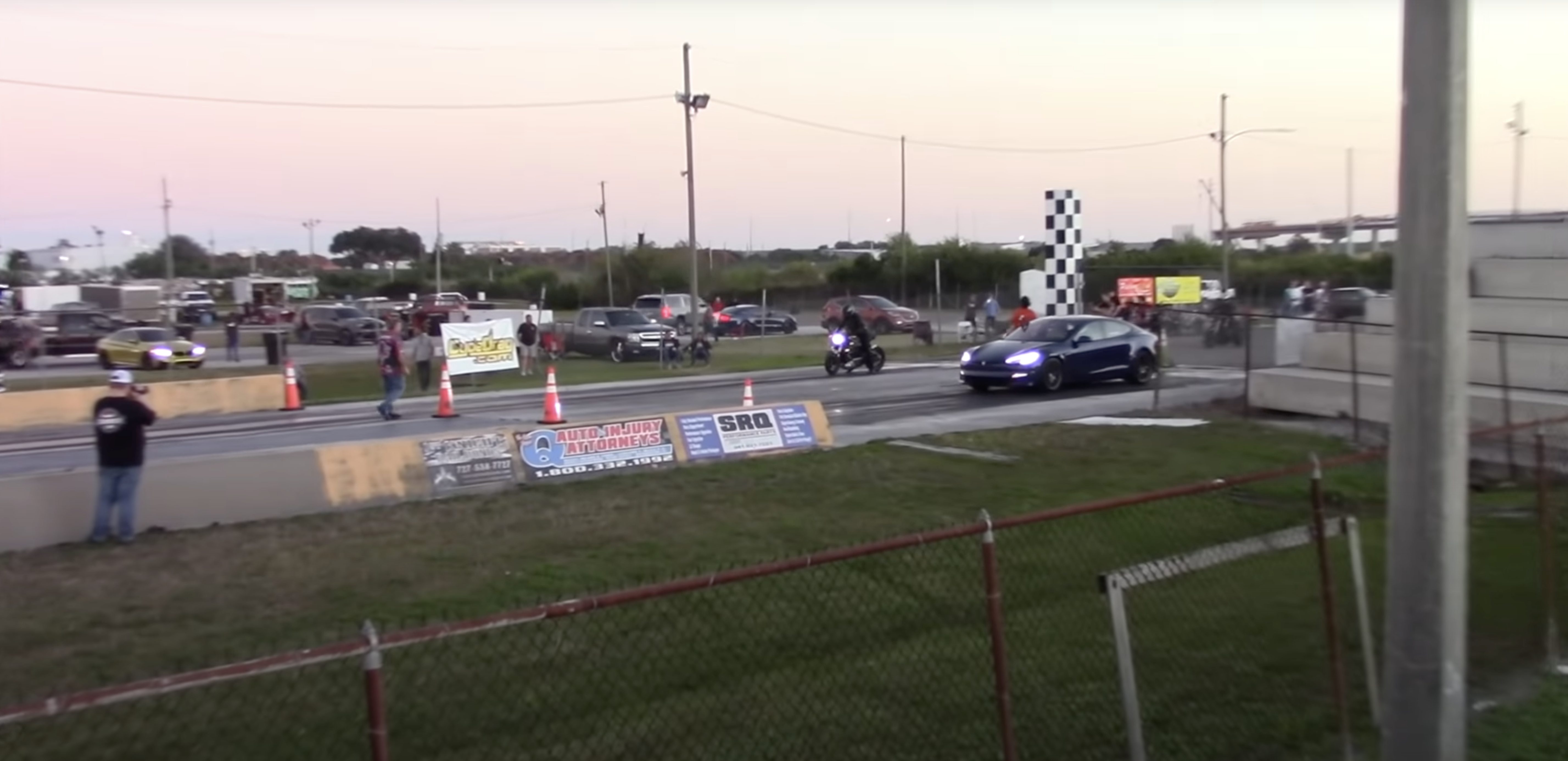 A view of a drag race between a Tesla model s plaid and a Harley-Davidson LiveWire One