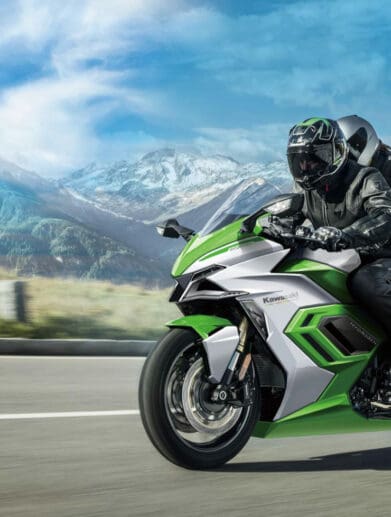 A view of a Kawasaki rider riding beyond a scope of mountains