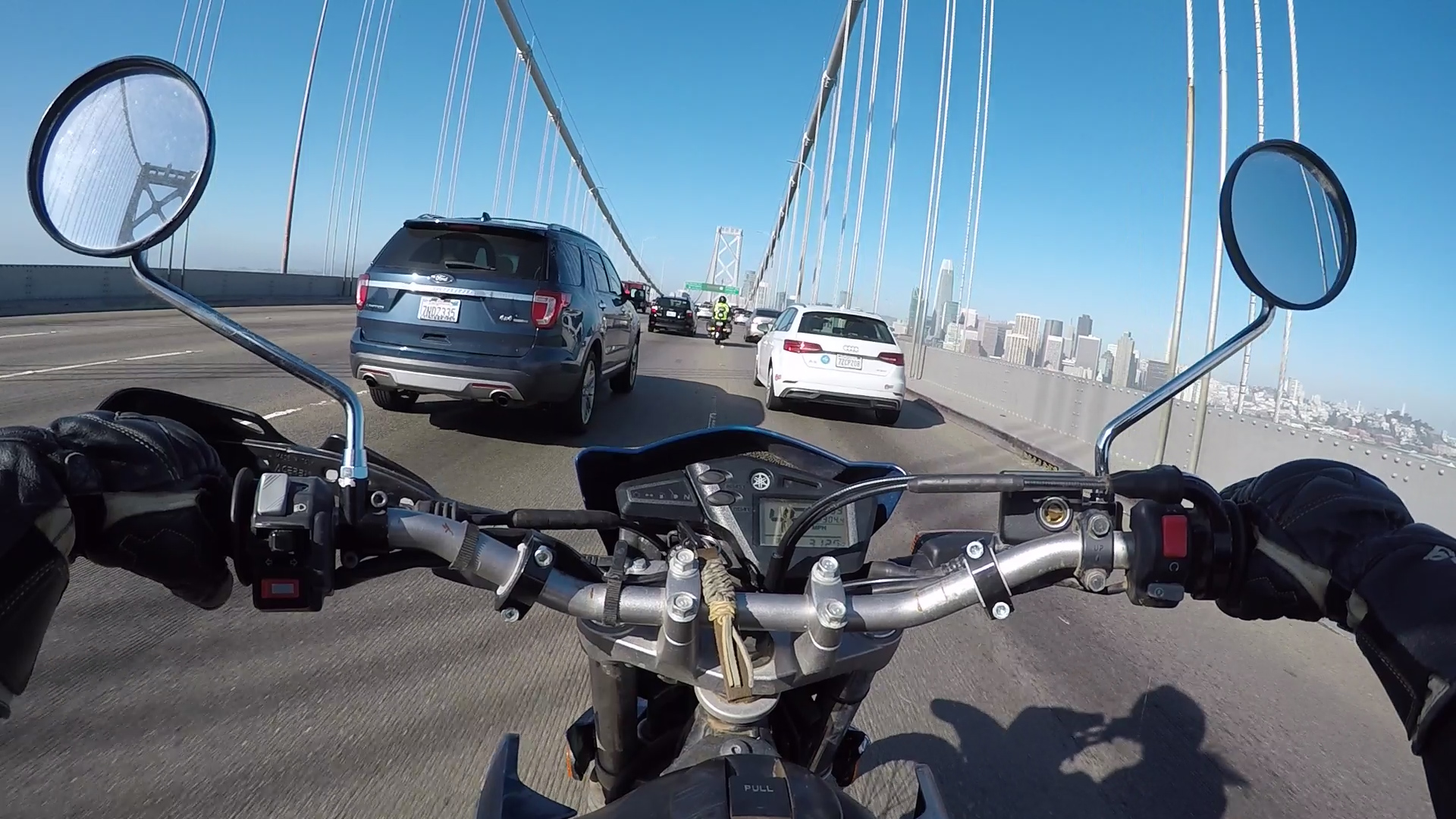 A view of a motorcyclist on a bridge in traffic