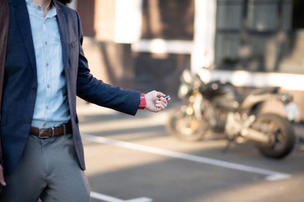 A man in a jacket locking a motorcycle