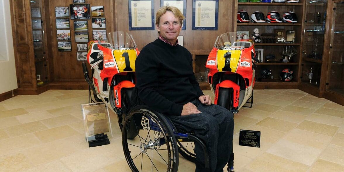 Wayne Rainey in his wheelchair with his championship winning bikes behind him