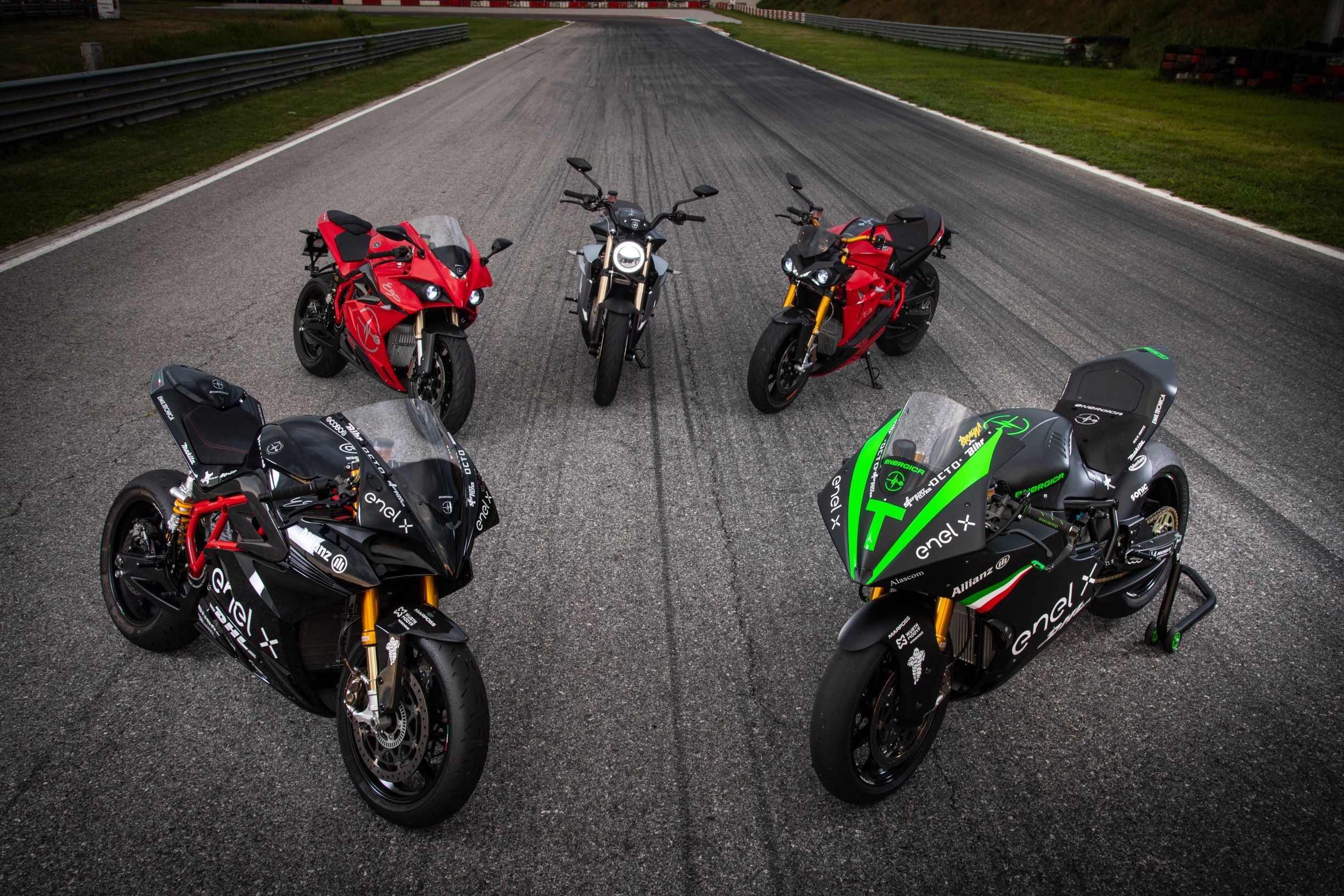 Energica motorcycles against a dark asphalt pavement and verdant background