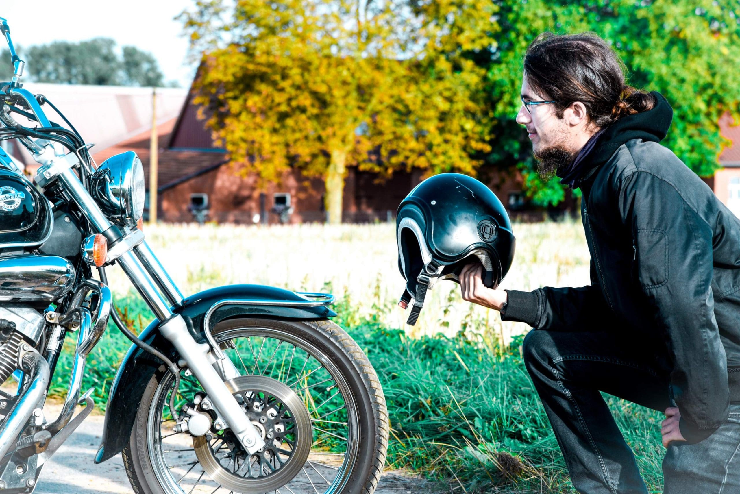 a man bending on the knee to a motorcycle that was just sold