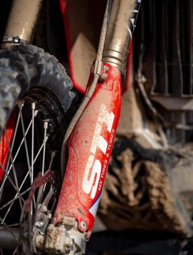 Closeup of muddy front fork suspension on motorcycle