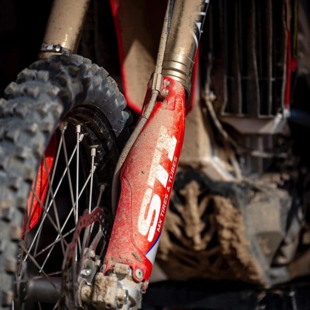 Closeup of muddy front fork suspension on motorcycle