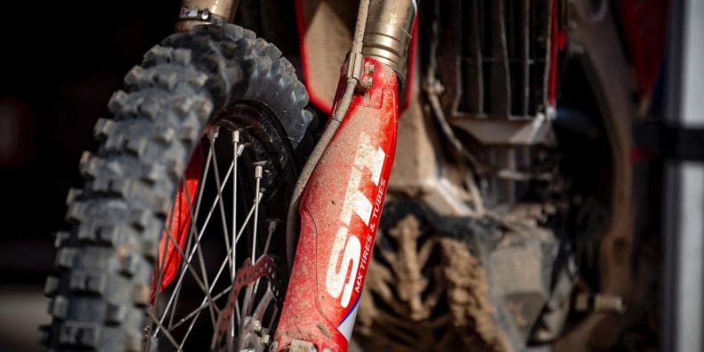 Closeup of muddy front fork suspension on motorcycle