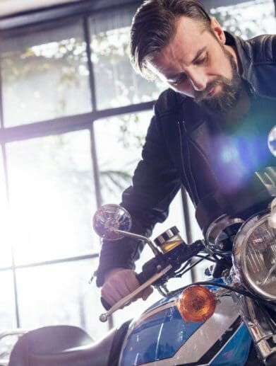 man fixing a motorcycle in garage