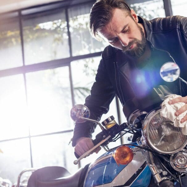 man fixing a motorcycle in garage