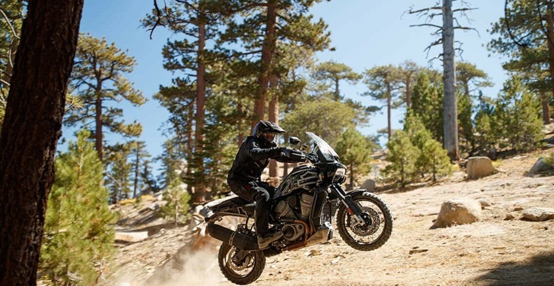 A new Harley-Davidson Pan America motorcycle launches of a jump in a desert during the North American launch.