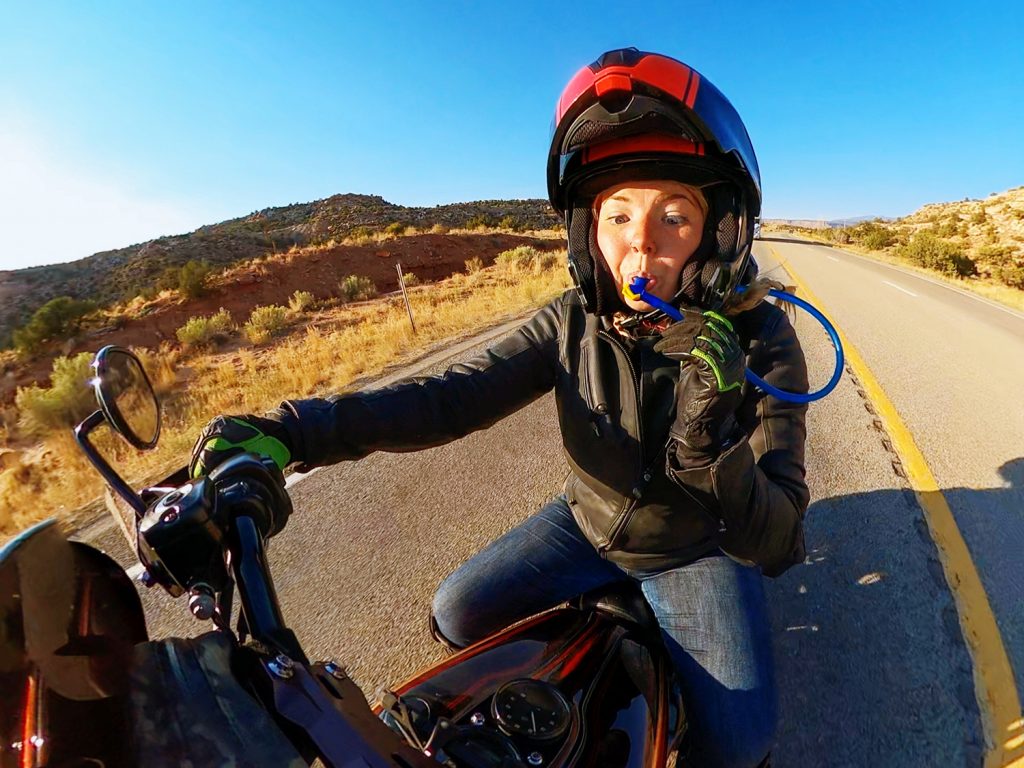 A female motorcyclist drinking while on the road. Photo courtesy of Ride to Food. 