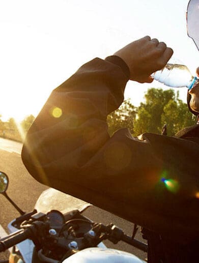 A female motorcycle rider drinking water on a break. Photo courtesy of the Orangeville country BMW Dealership.