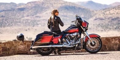 A woman in the desert next to a motorcycle. Photo sourced from CNBC.