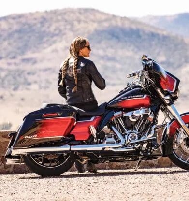 A woman in the desert next to a motorcycle. Photo sourced from CNBC.